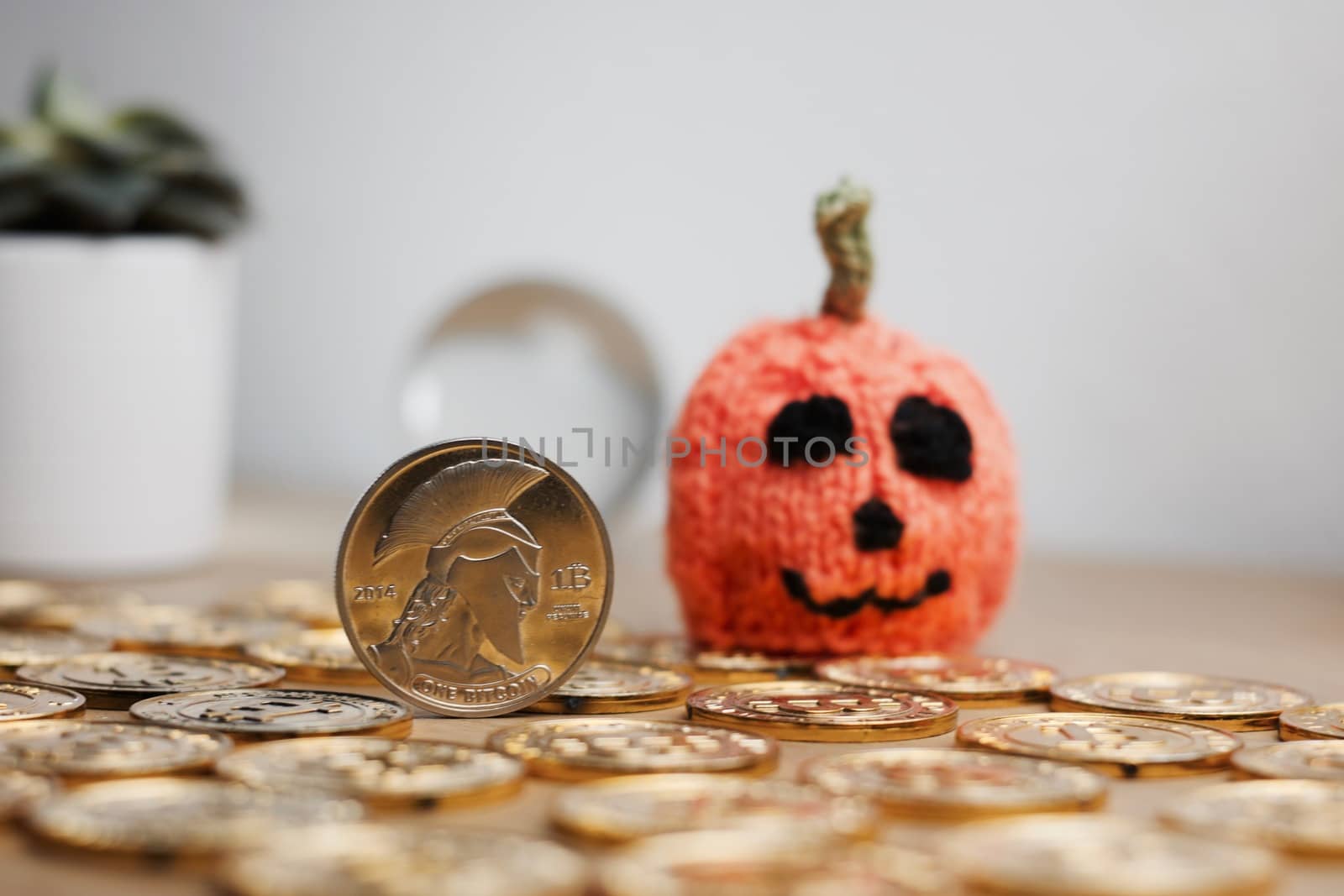 Digital currency physical metal bitcoin coin. Halloween pumpkin concept.