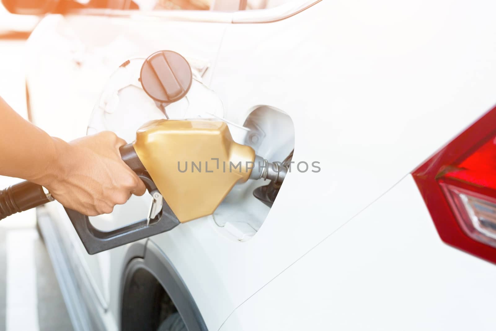 Man handle refilling the car with fuel at the refuel station by boytaro1428@gmail.com