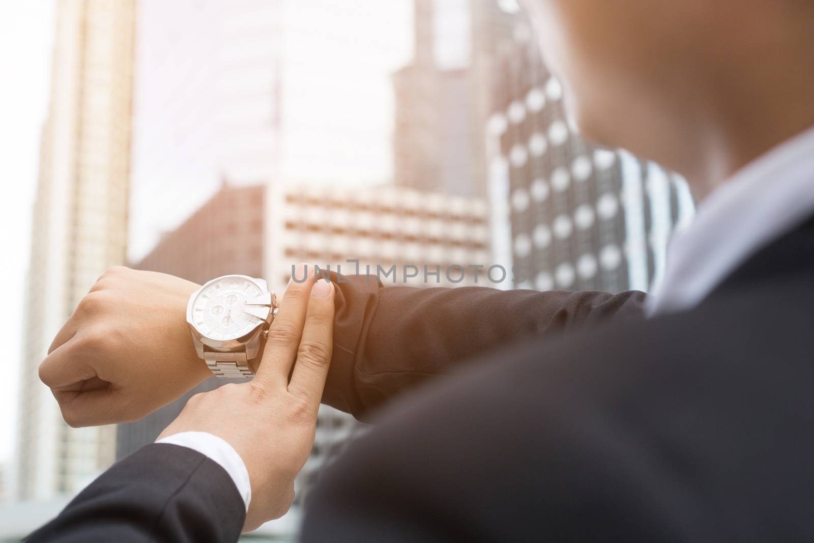 closeup businessman hand, come to work late he looks watch on the time and hurrying