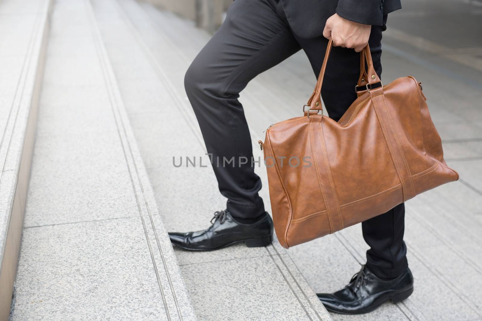 Businessman with briefcase brown leather bag walking upstairs ,Fighting against obstacles Climb up to Successful finish concept. by boytaro1428@gmail.com