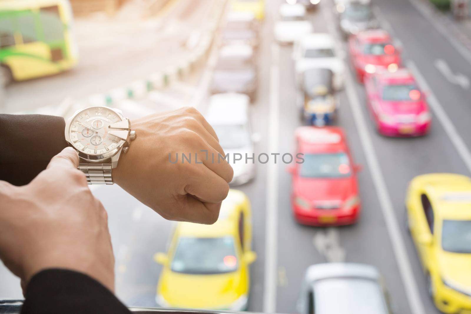 young businessman looks at the watch on the road in rush hour.