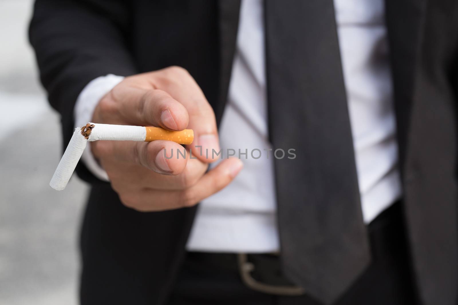 businessman stand smoking Cigarettes in hand.