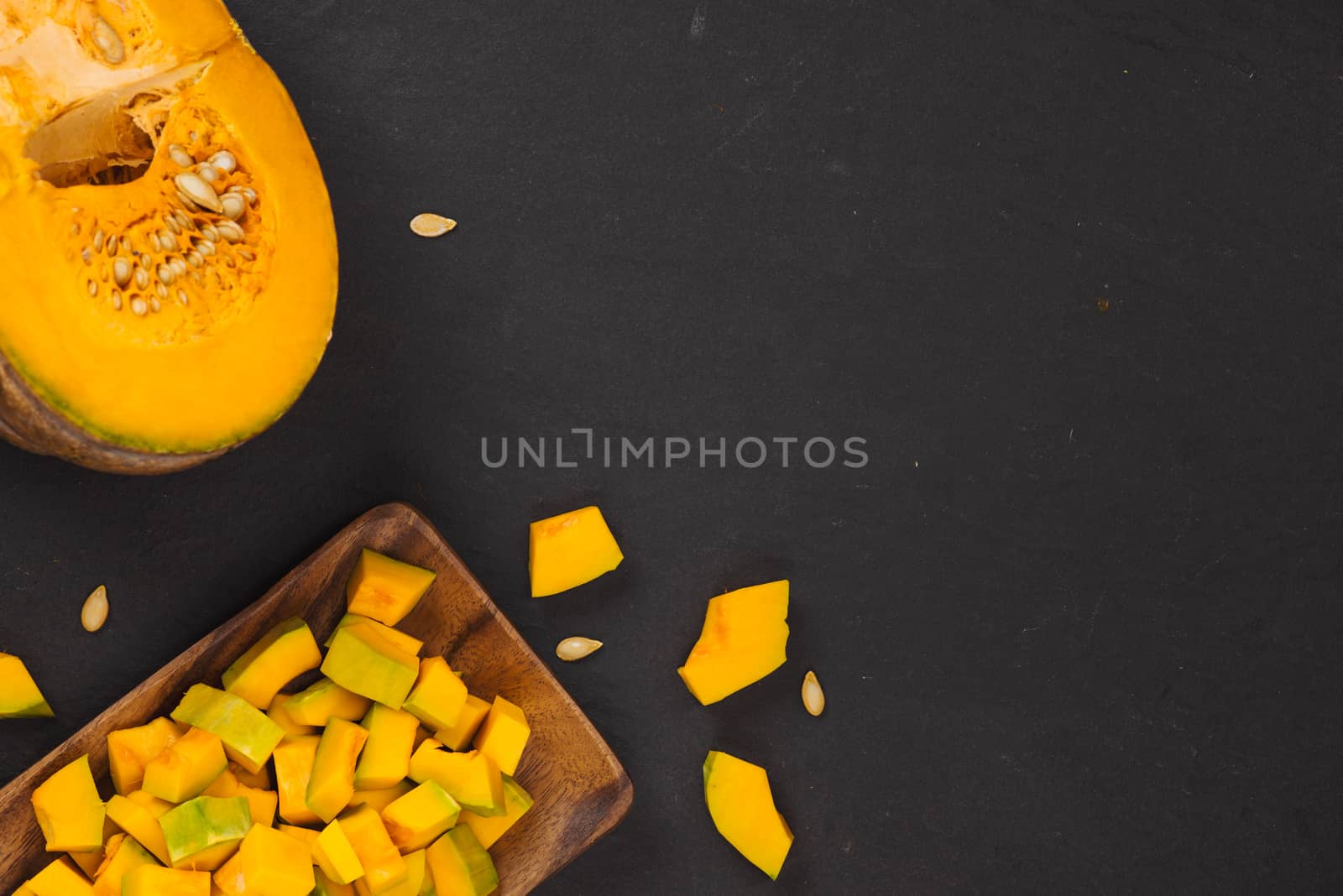 Delicious fresh pieces of ripe pumpkin on wooden background