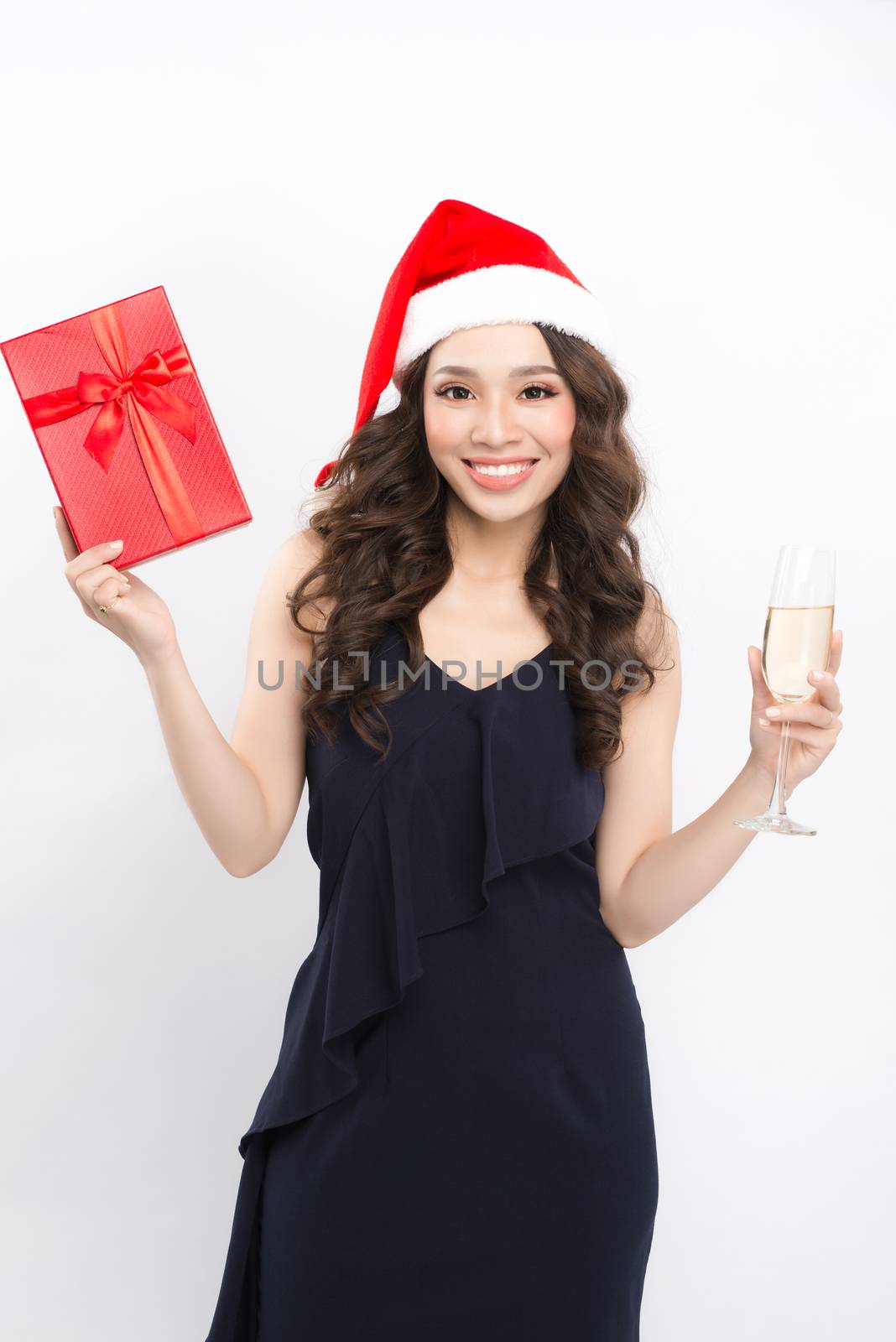Young celebrating woman in red dress and santa claus hold wine g by makidotvn