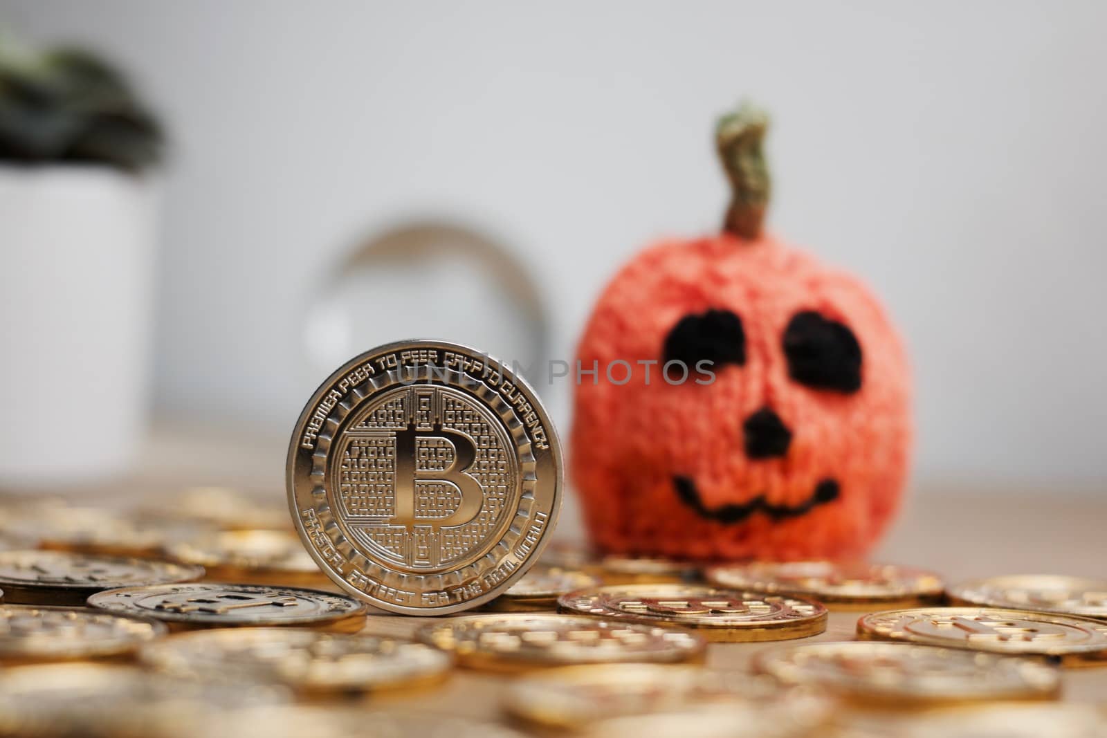 Digital currency physical metal bitcoin coin. Halloween pumpkin concept.