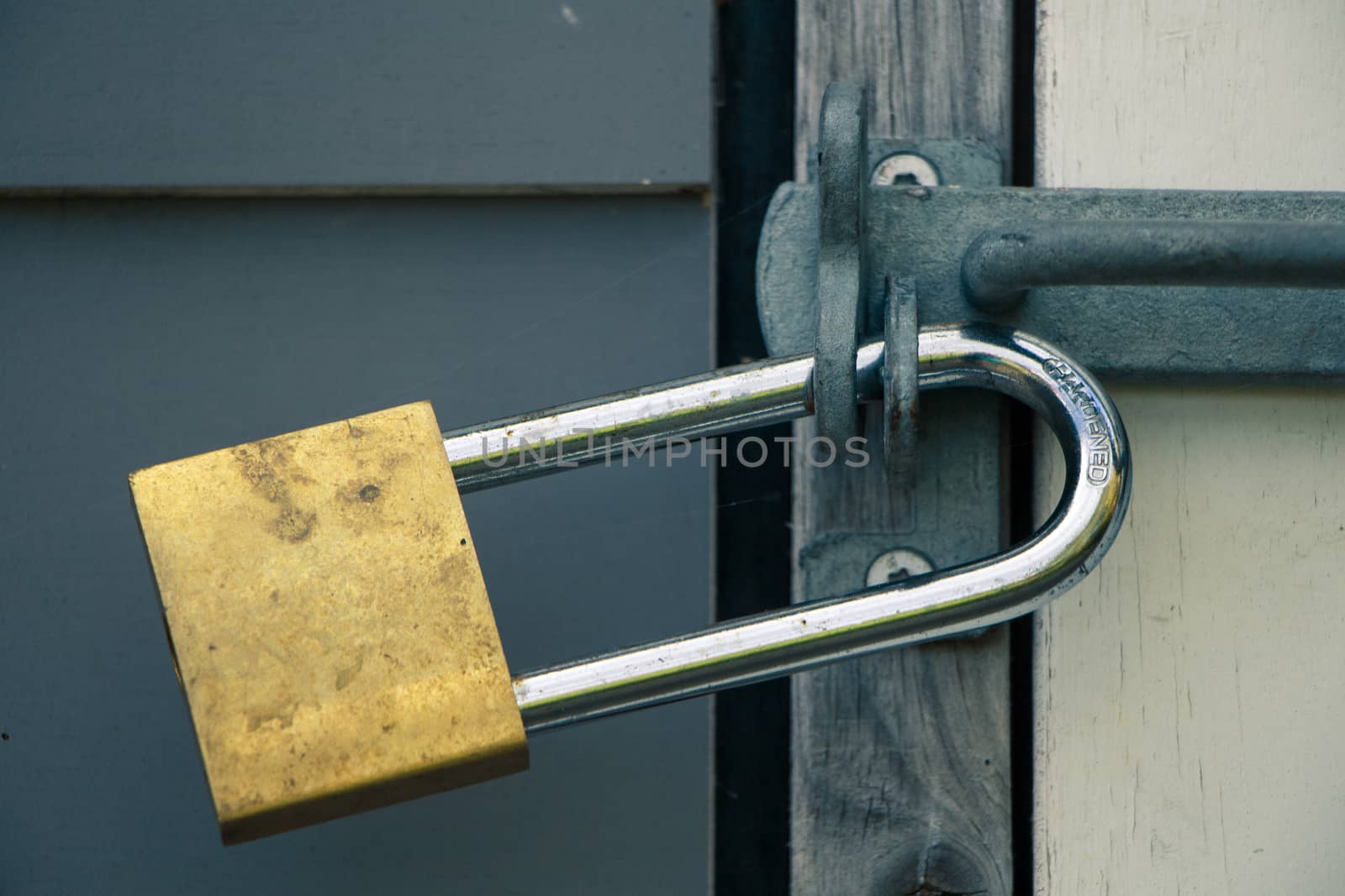Closeup on big gold and silver lock locking doorknob.