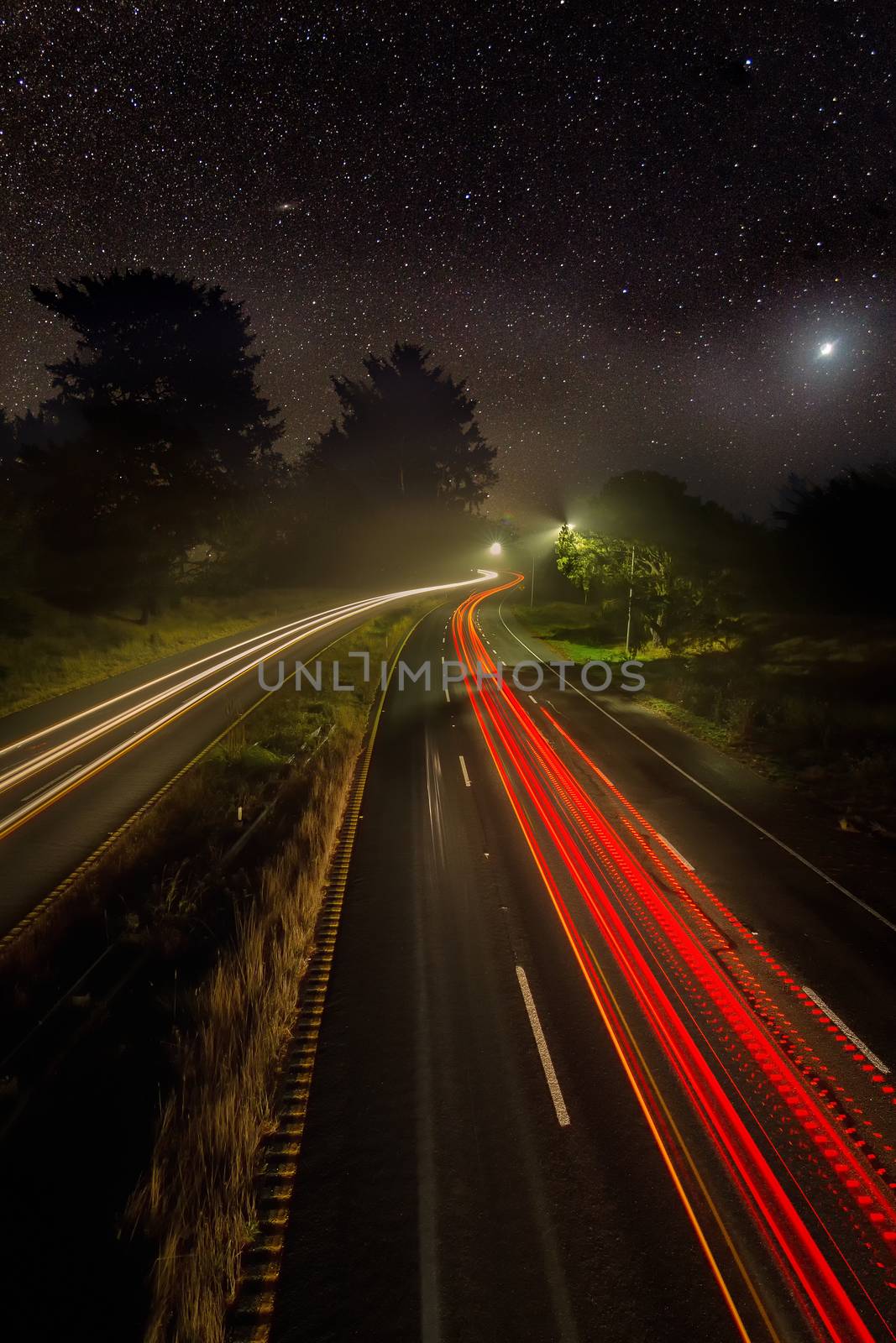 Night Image of Cars on a Highway Under the Stars by backyard_photography