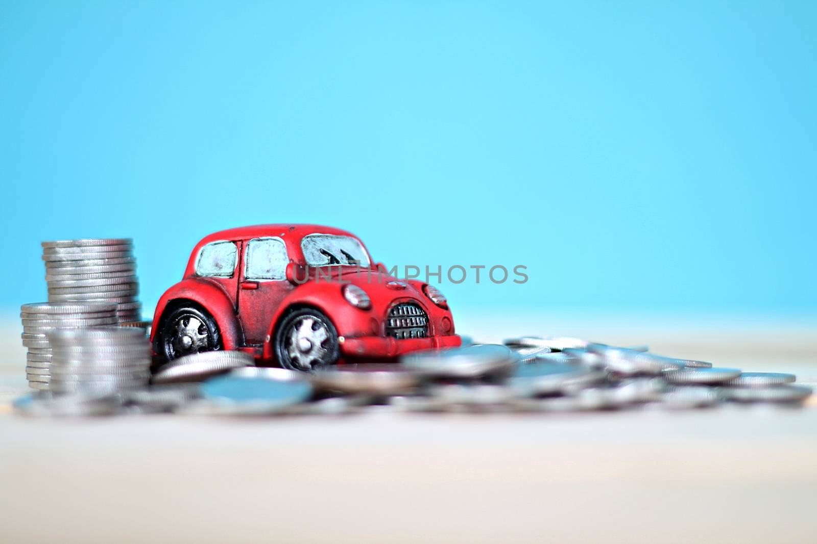 Business, finance, saving money or car loan concept : Miniature car model and coins stack on desk table