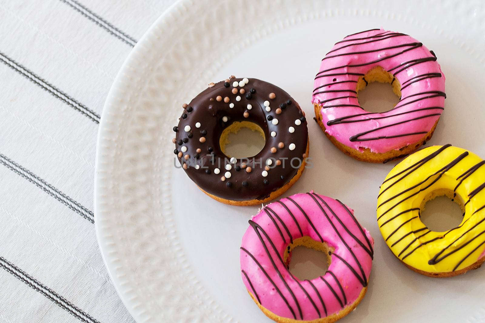 assorted donuts with chocolate frosted, pink glazed and sprinkles donuts by 3KStudio