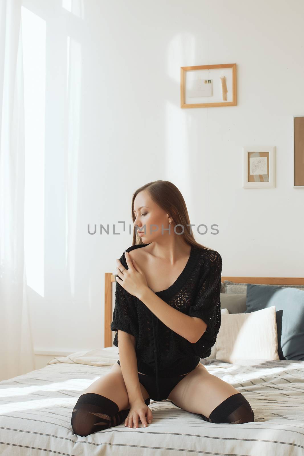 Beautiful young woman in a sexy black underwear by 3KStudio
