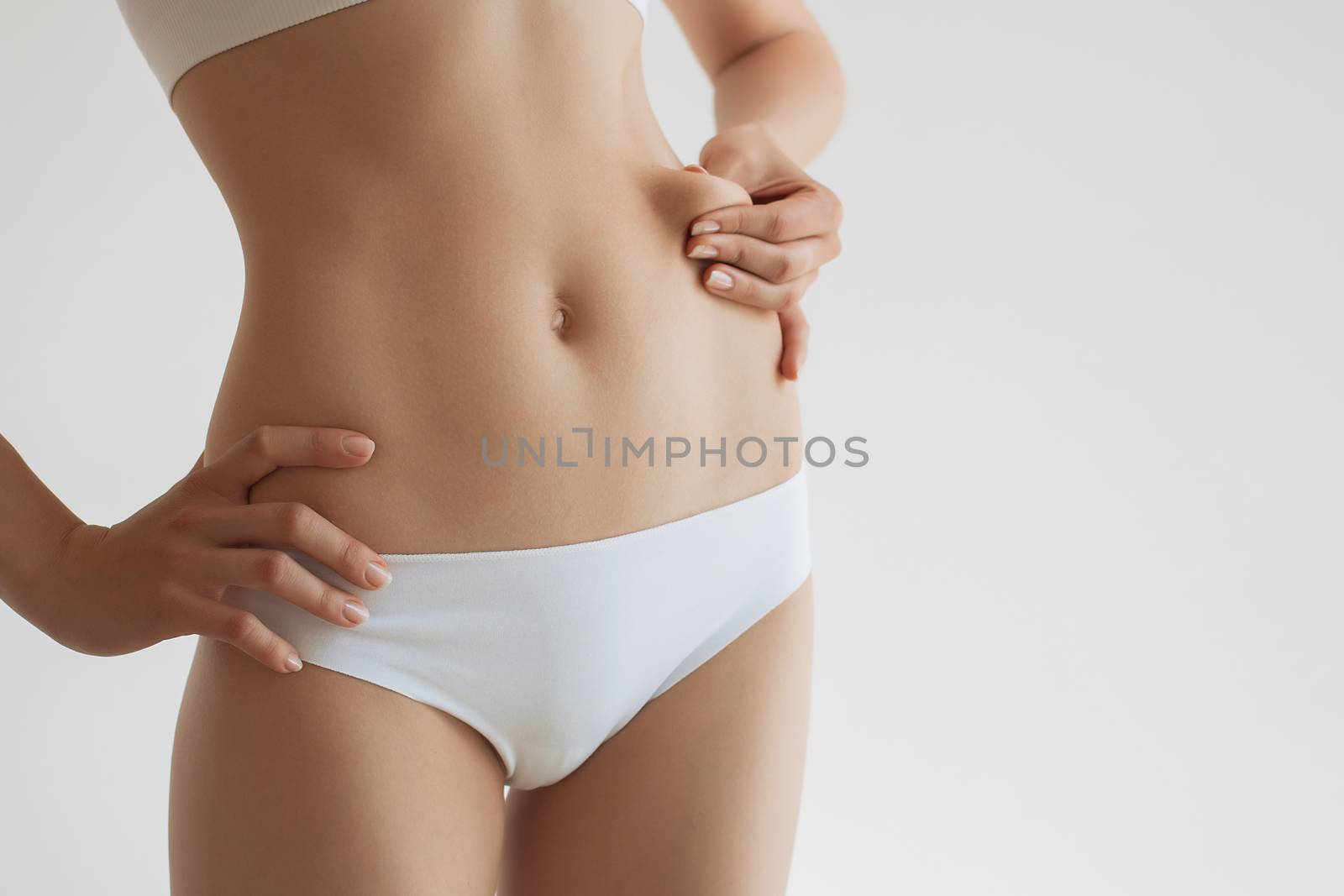 Young beautiful fitness girl demonstrates your press.