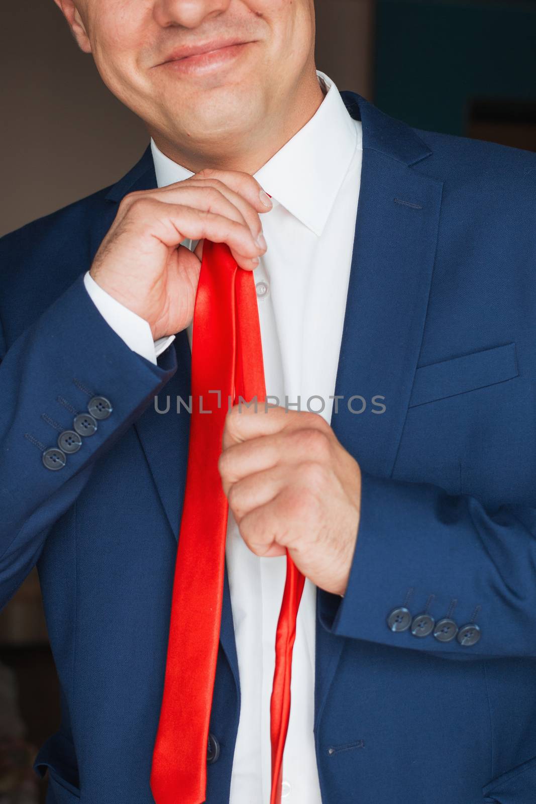 Elegant businessman, a man with a clock straightens his tie