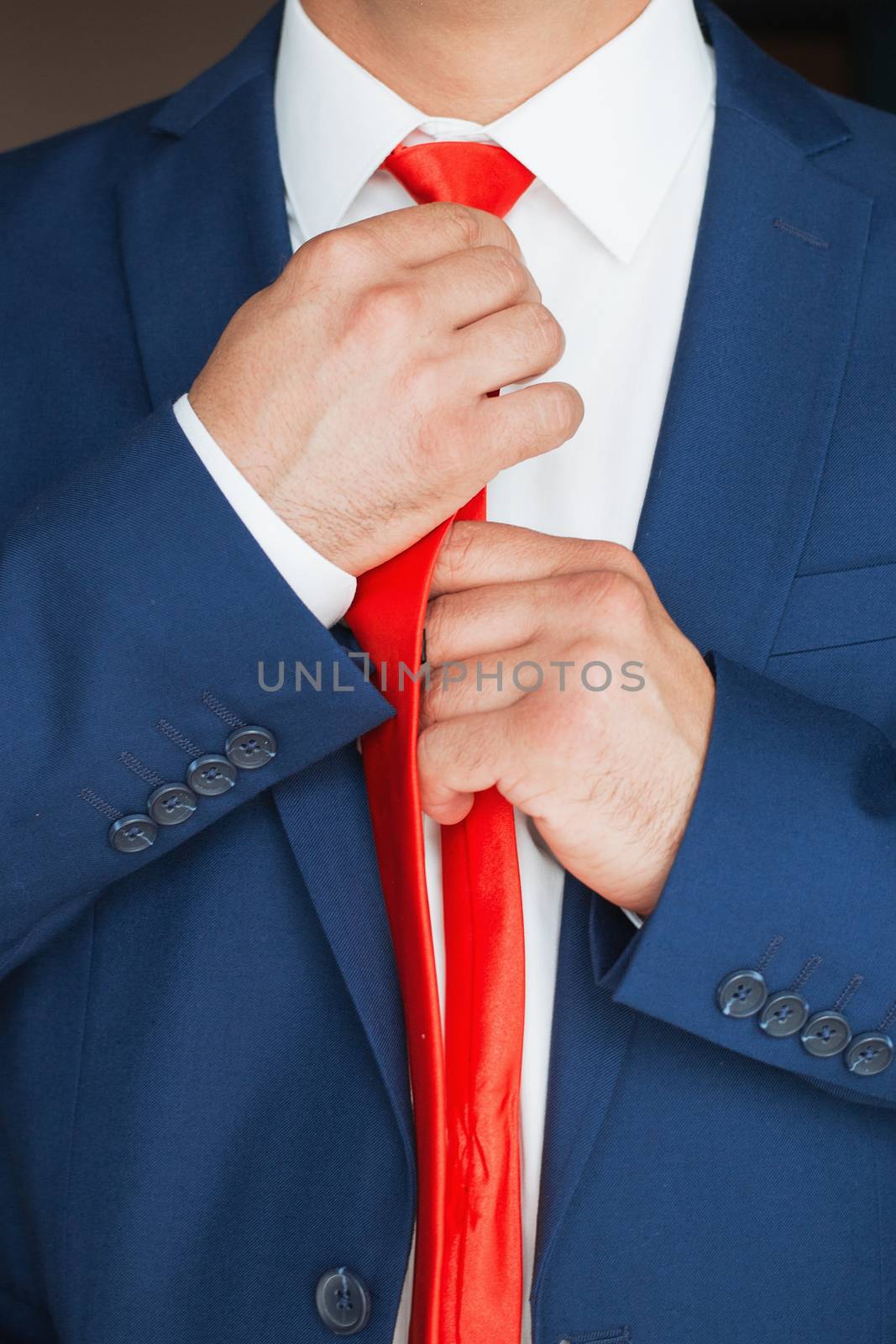 Elegant businessman, a man with a clock straightens his tie