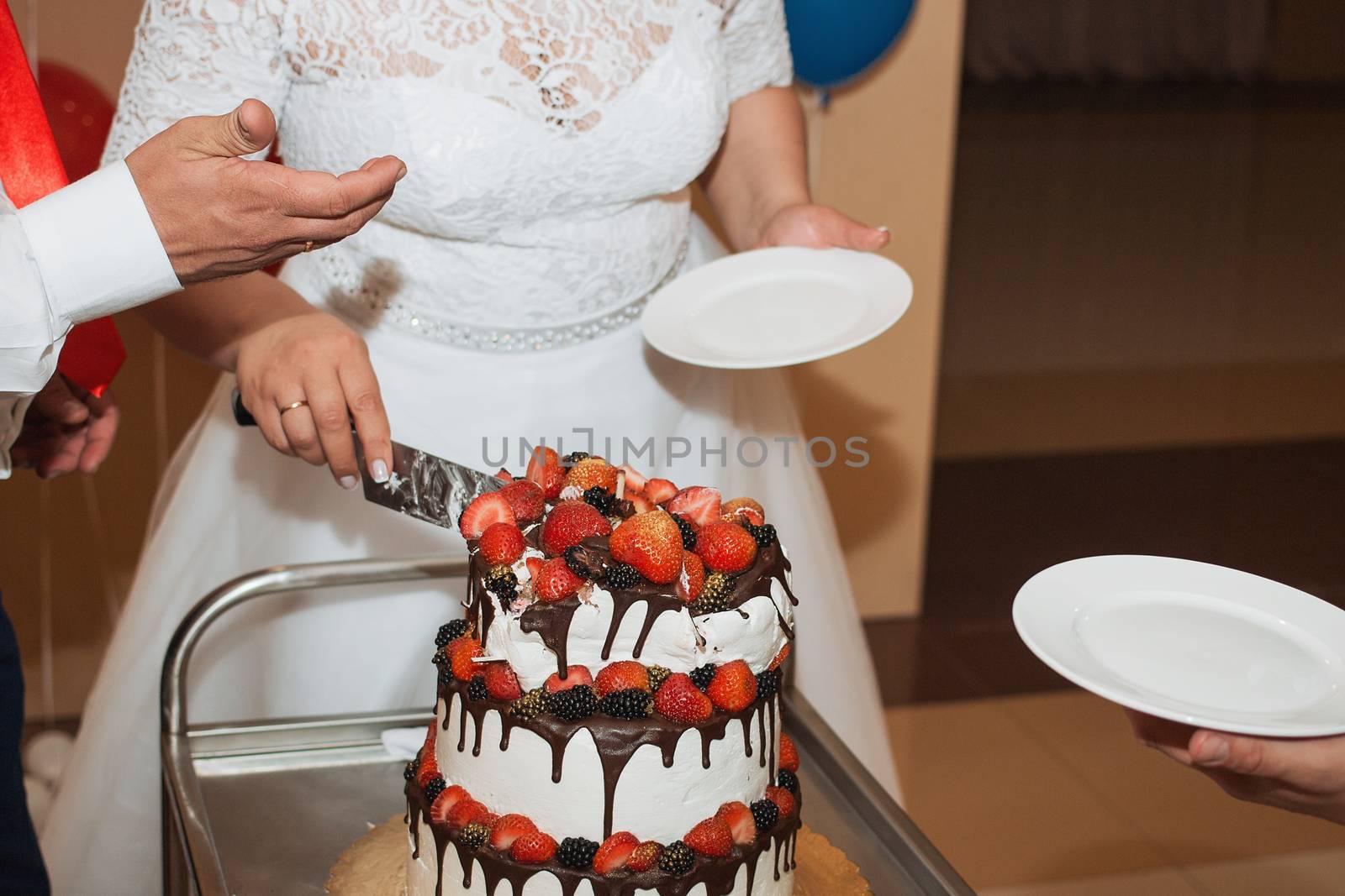 elegant pretty young bride and groom cut the wedding cake by 3KStudio