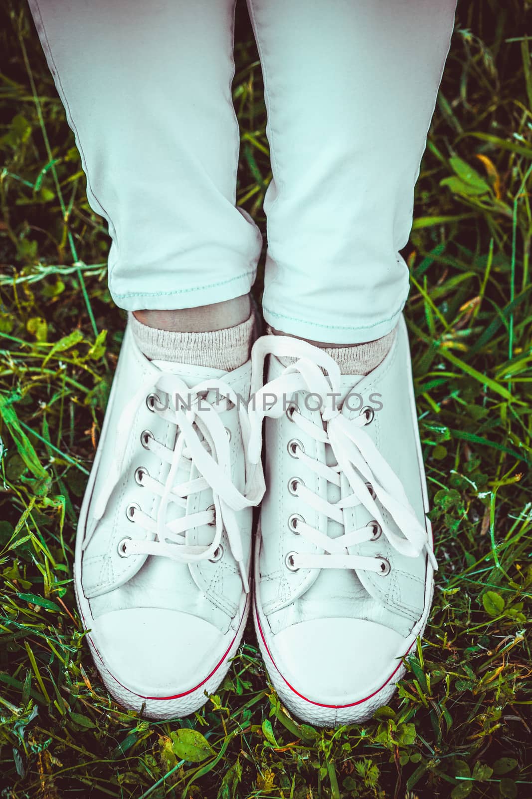 female feet in white sneakers close up by boys1983@mail.ru