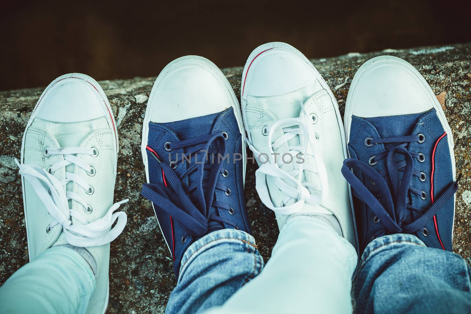 Close up of male and female's feet in sneakers by boys1983@mail.ru