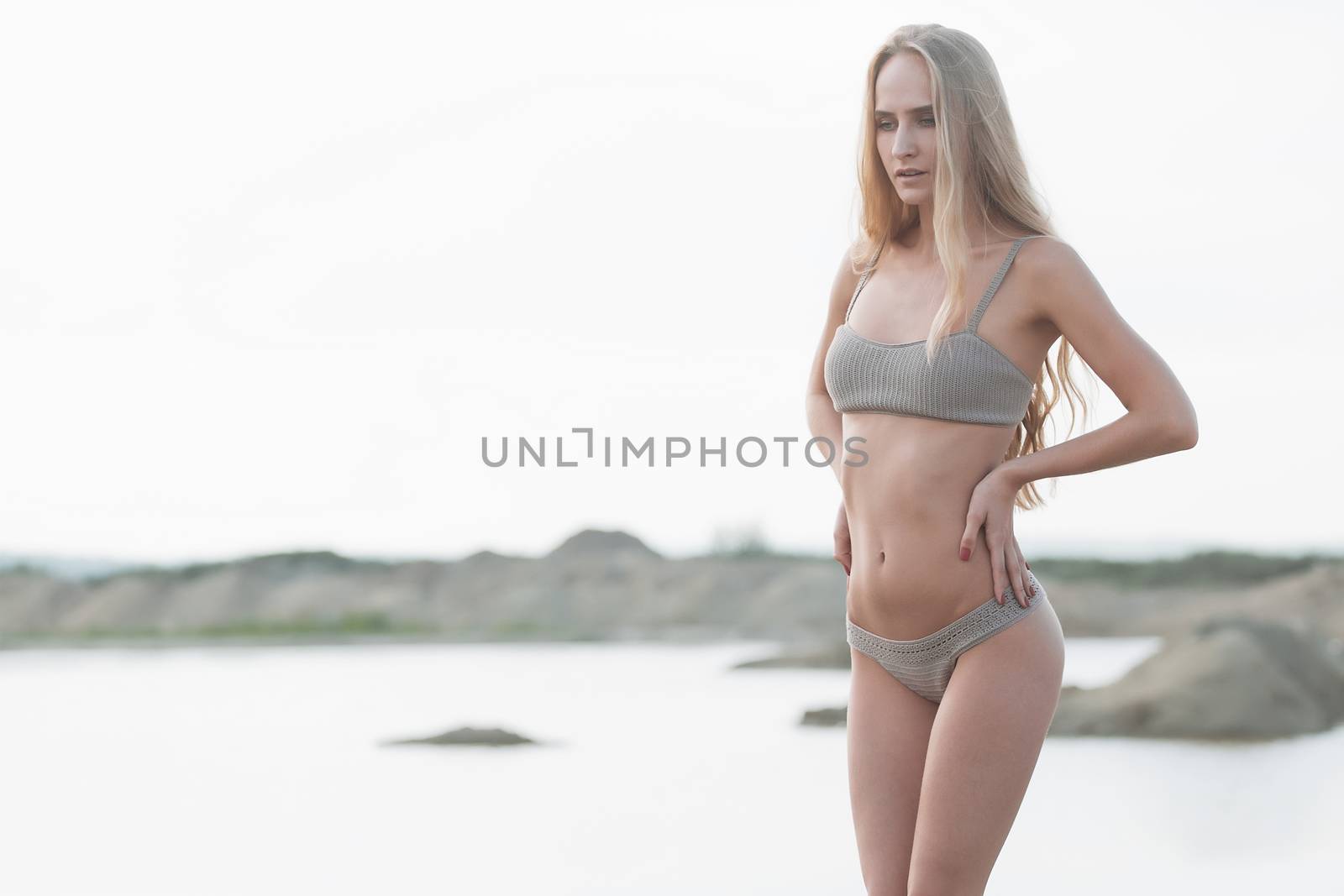 Girl on the sandy beach in a bathing suit.