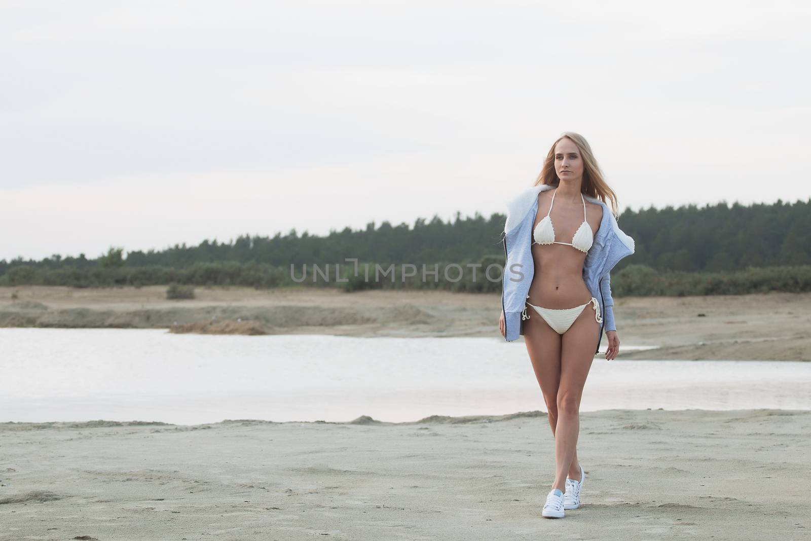 Girl on the sandy beach in a bathing suit.