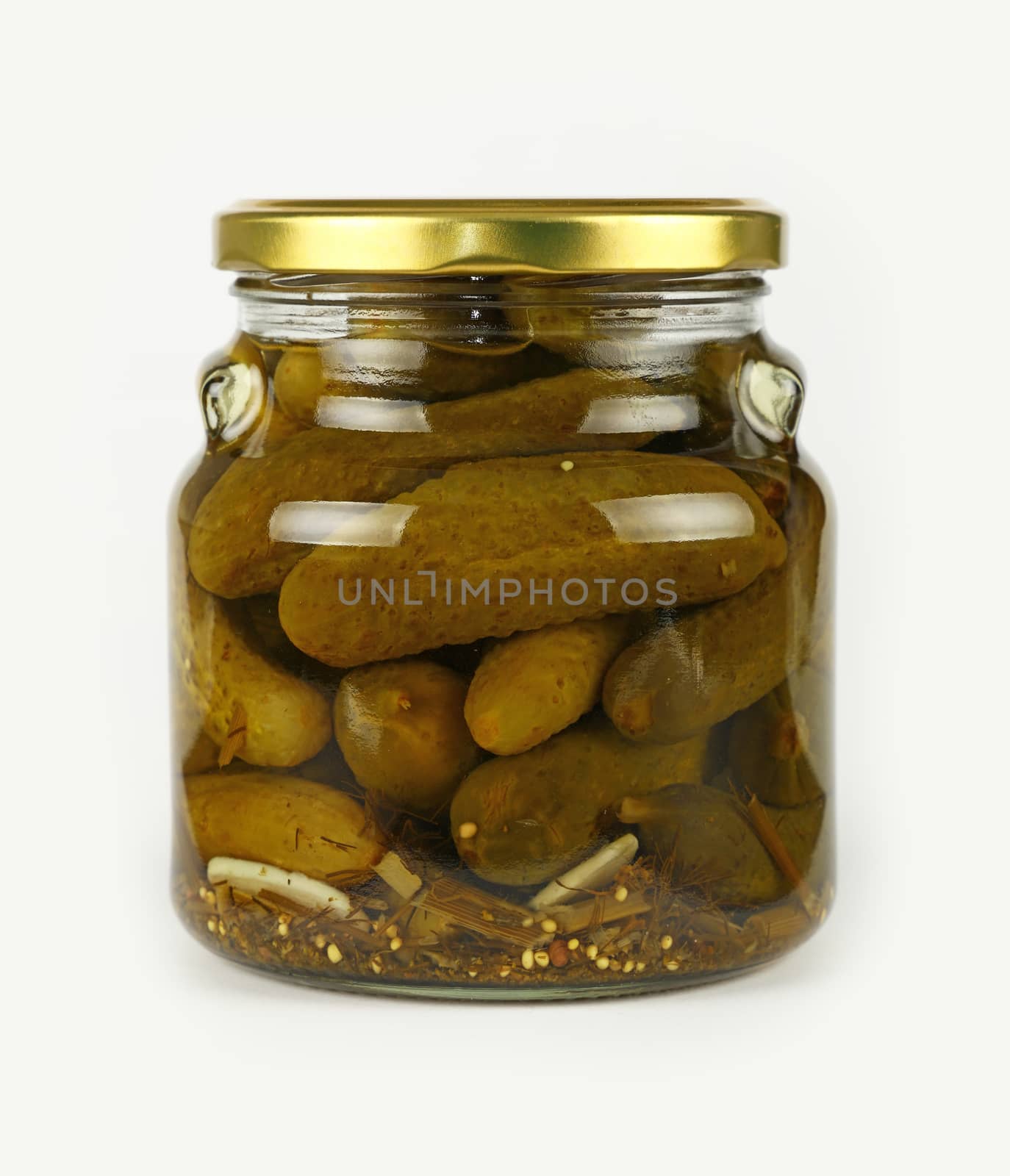 Close up of one glass jar of pickled small green gherkin cucumbers with golden lid over white background, low angle side view