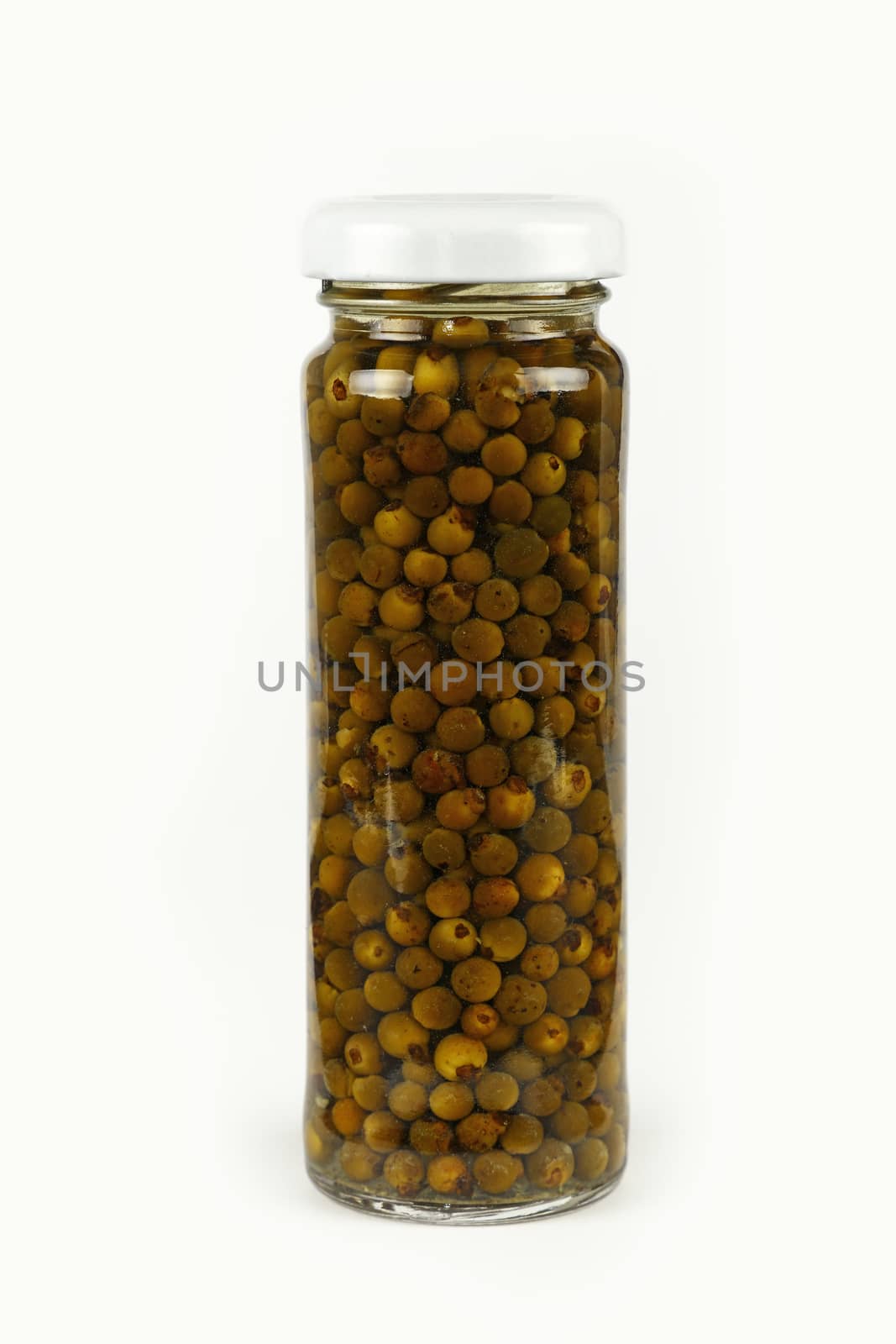 Close up of one small glass jar of pickled green hot peppercorns over white background, low angle side view