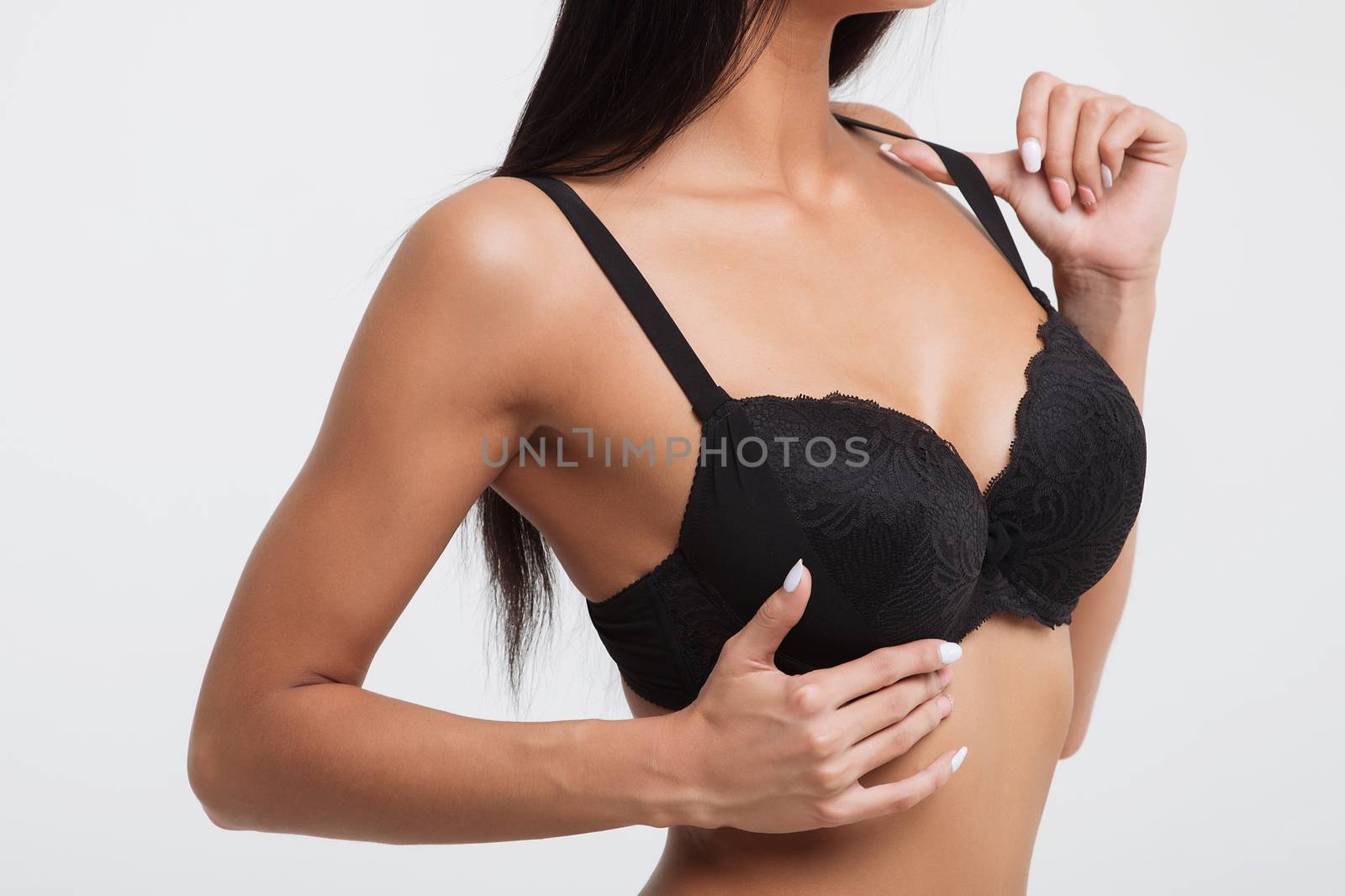 Sexy woman in a black lingerie on the white background.