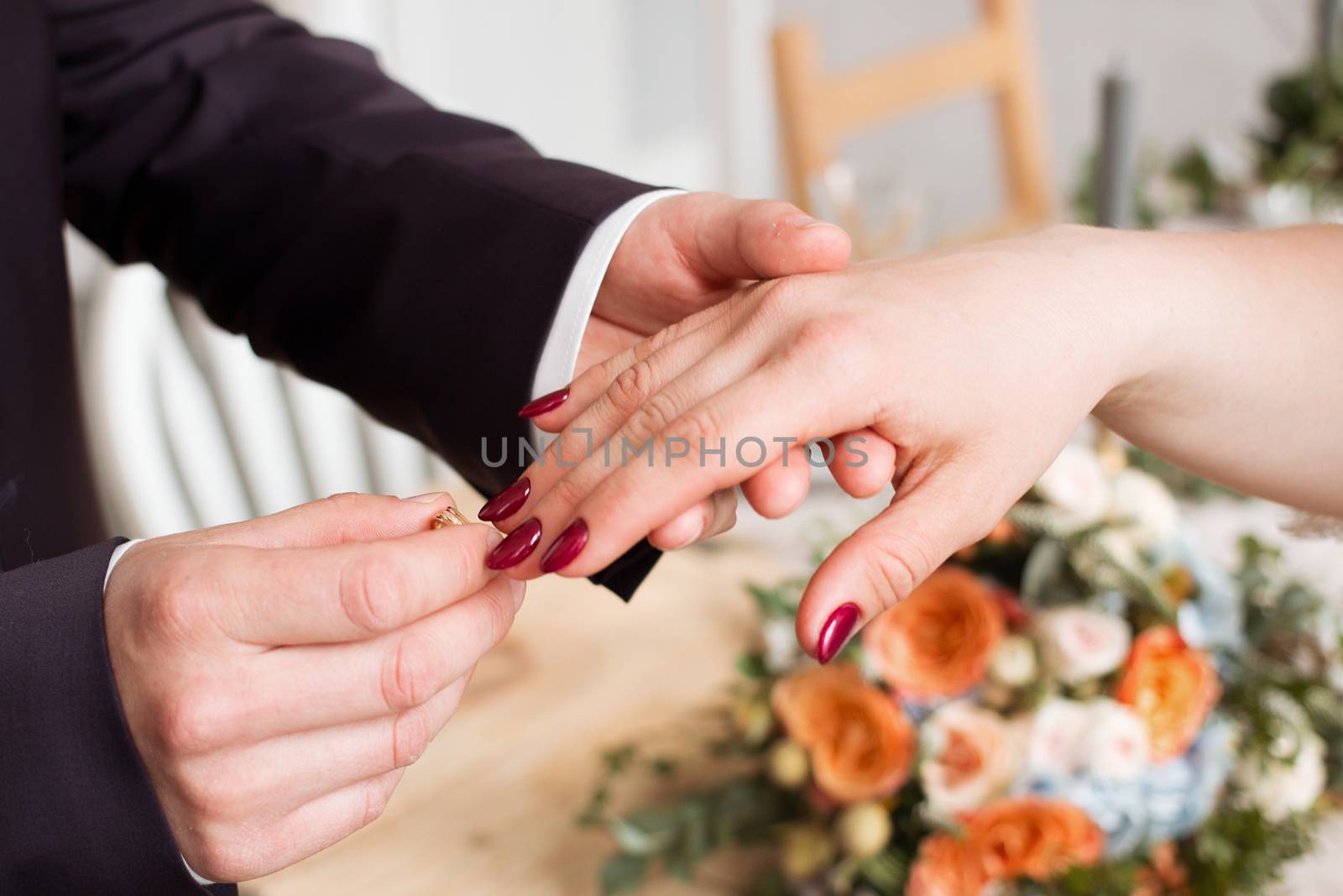 wedding rings and hands of bride and groom. young wedding couple at ceremony. matrimony. man and woman in love. two happy people celebrating becoming family by 3KStudio