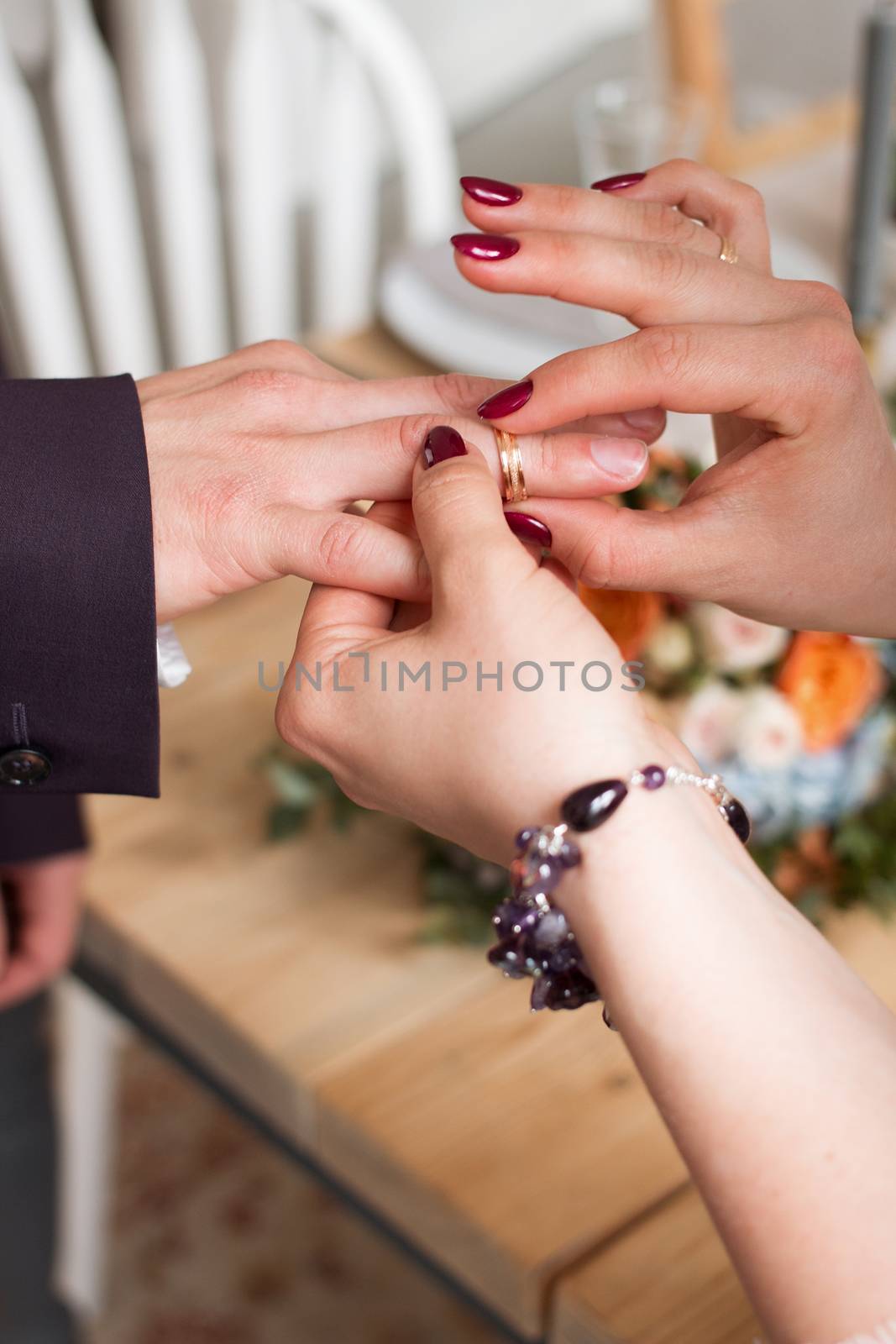 wedding rings and hands of bride and groom. young wedding couple at ceremony. matrimony. man and woman in love. two happy people celebrating becoming family by 3KStudio