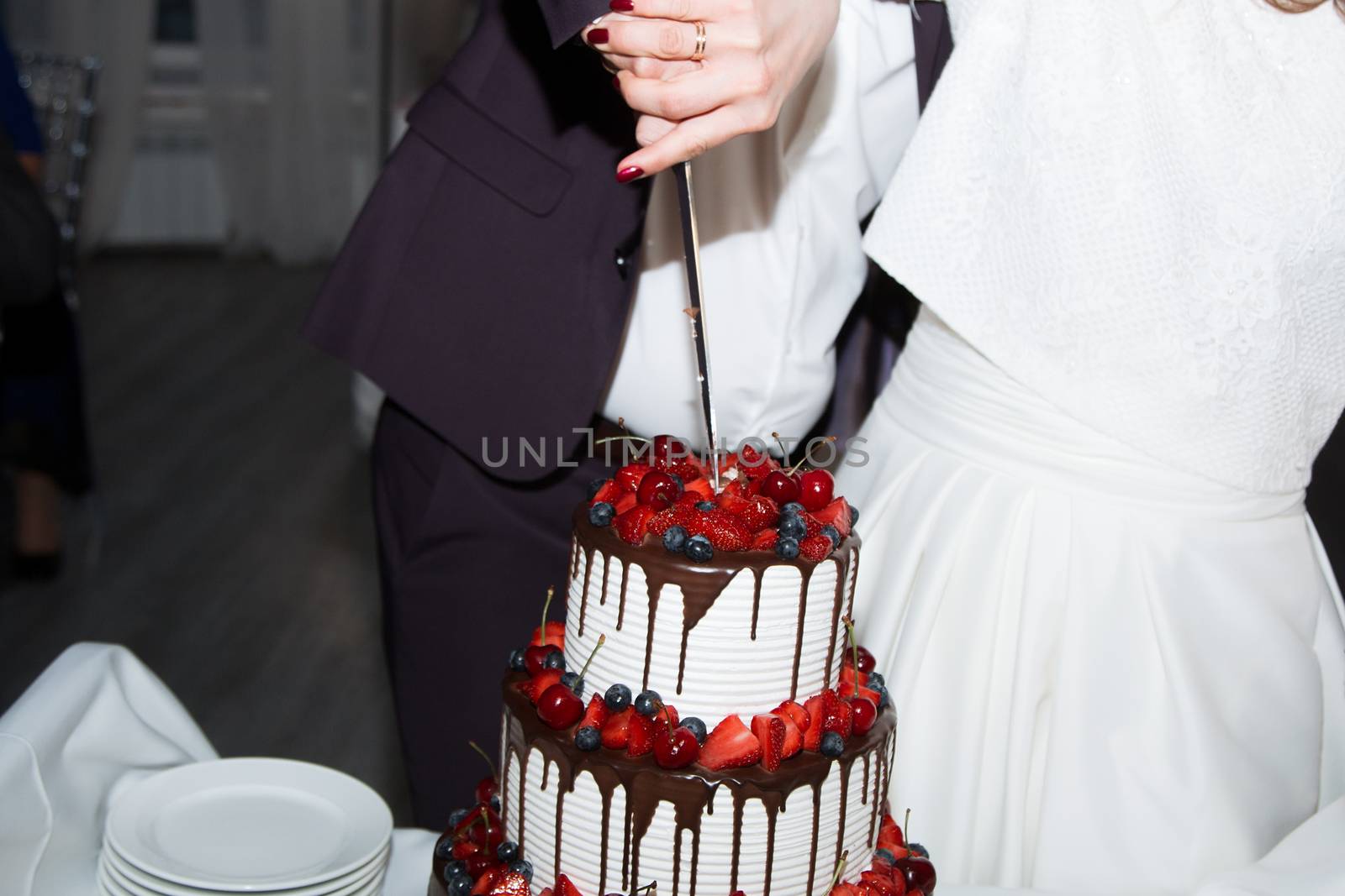 elegant pretty young bride and groom cut the wedding cake by 3KStudio
