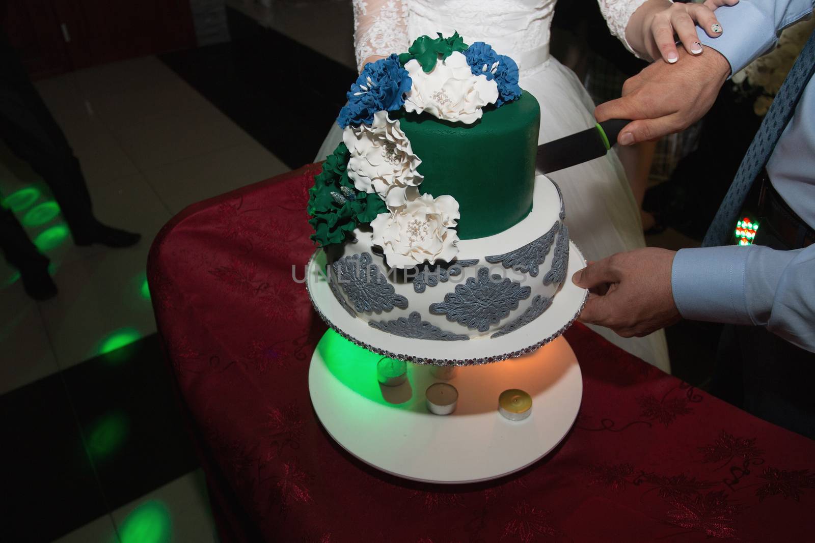 elegant pretty young bride and groom cut the wedding cake by 3KStudio