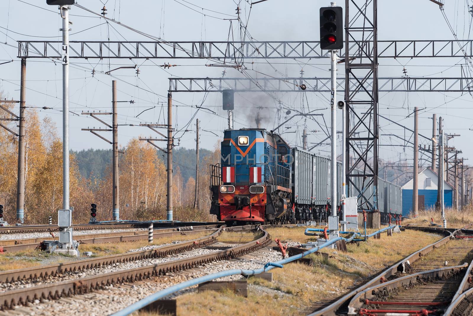 Freight train locomotive carrying with cargo on daylight.