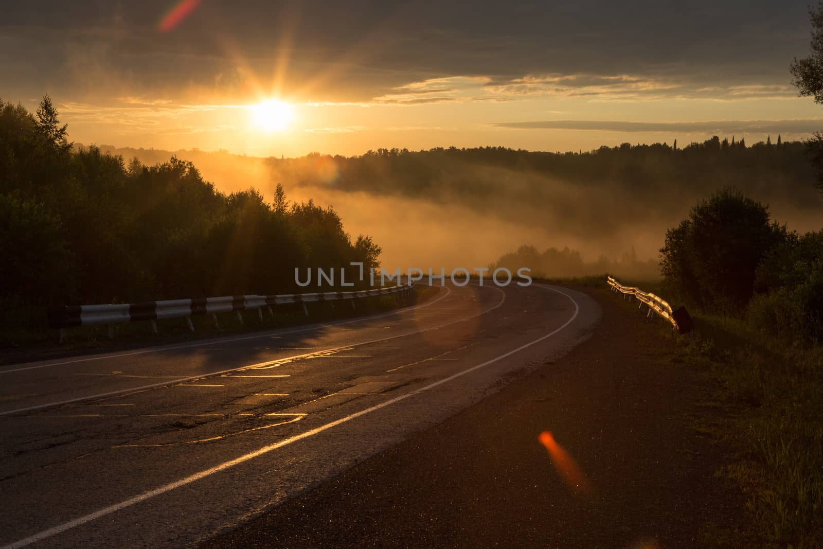 The curve of the road in the mountains. Sunset