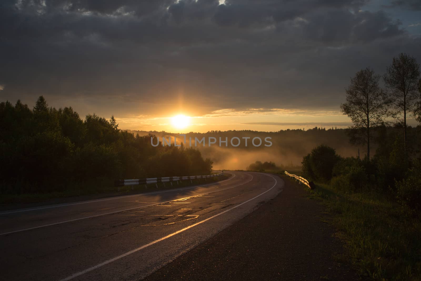 The curve of the road in the mountains. Sunset