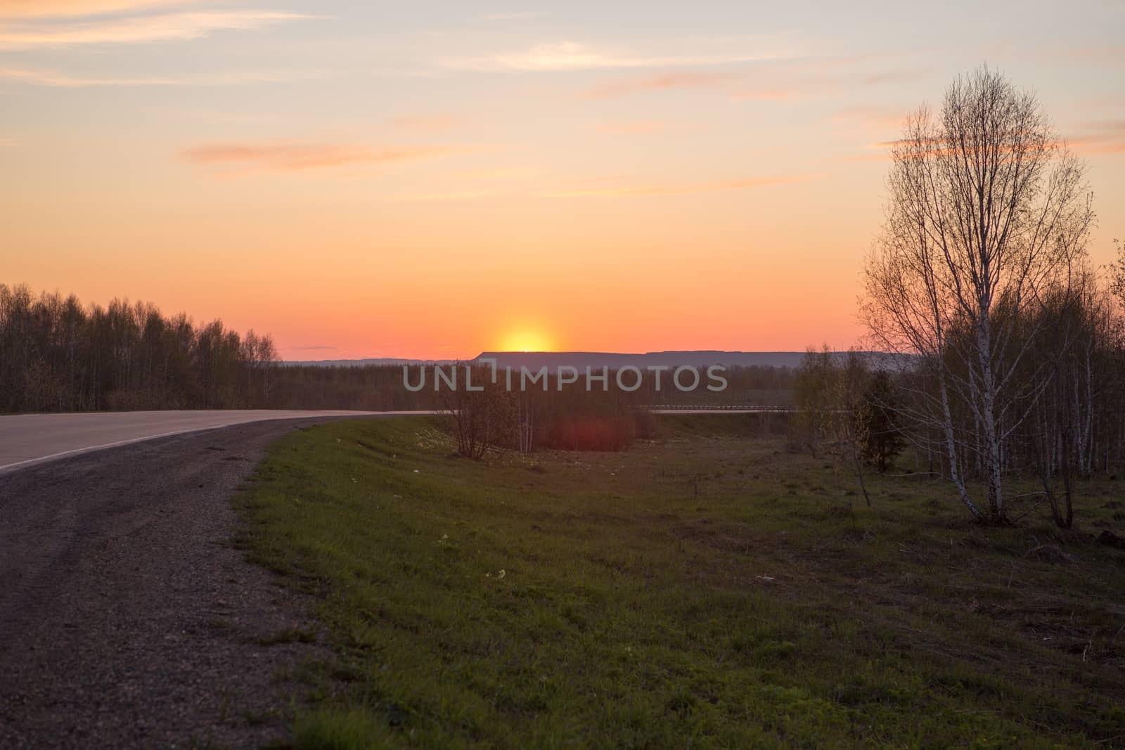 The curve of the road in the mountains. Sunset