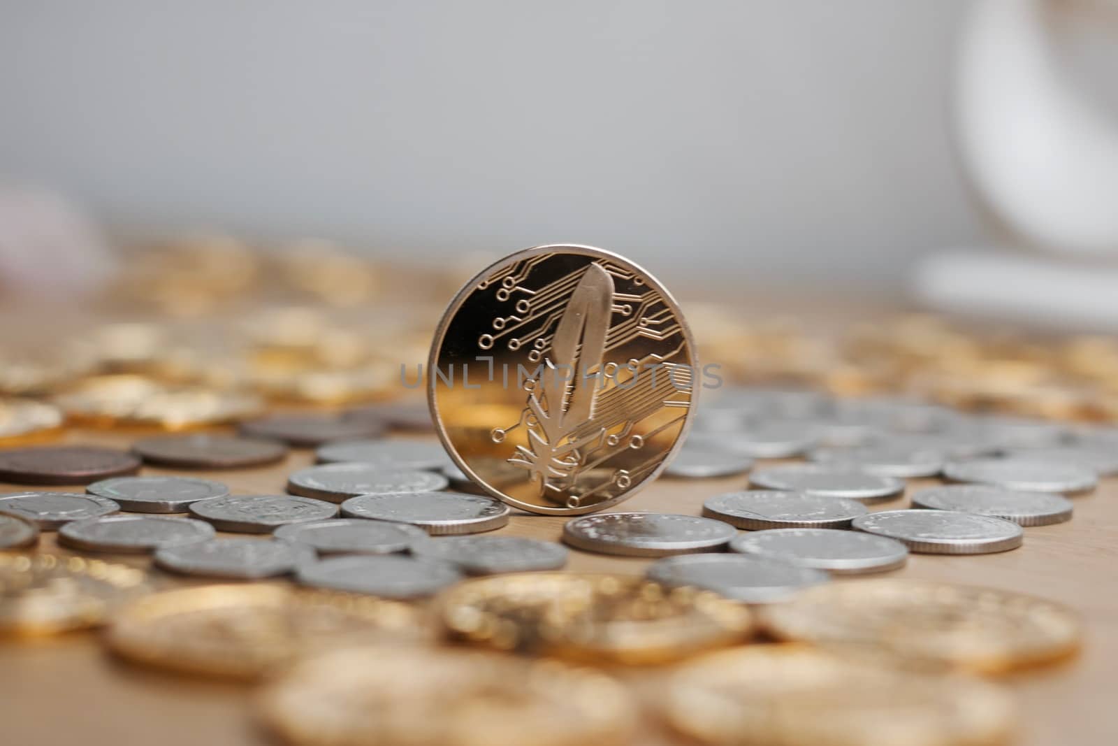 Digital currency physical metal gold feather coin with red heart. Cryptocurrency concept.