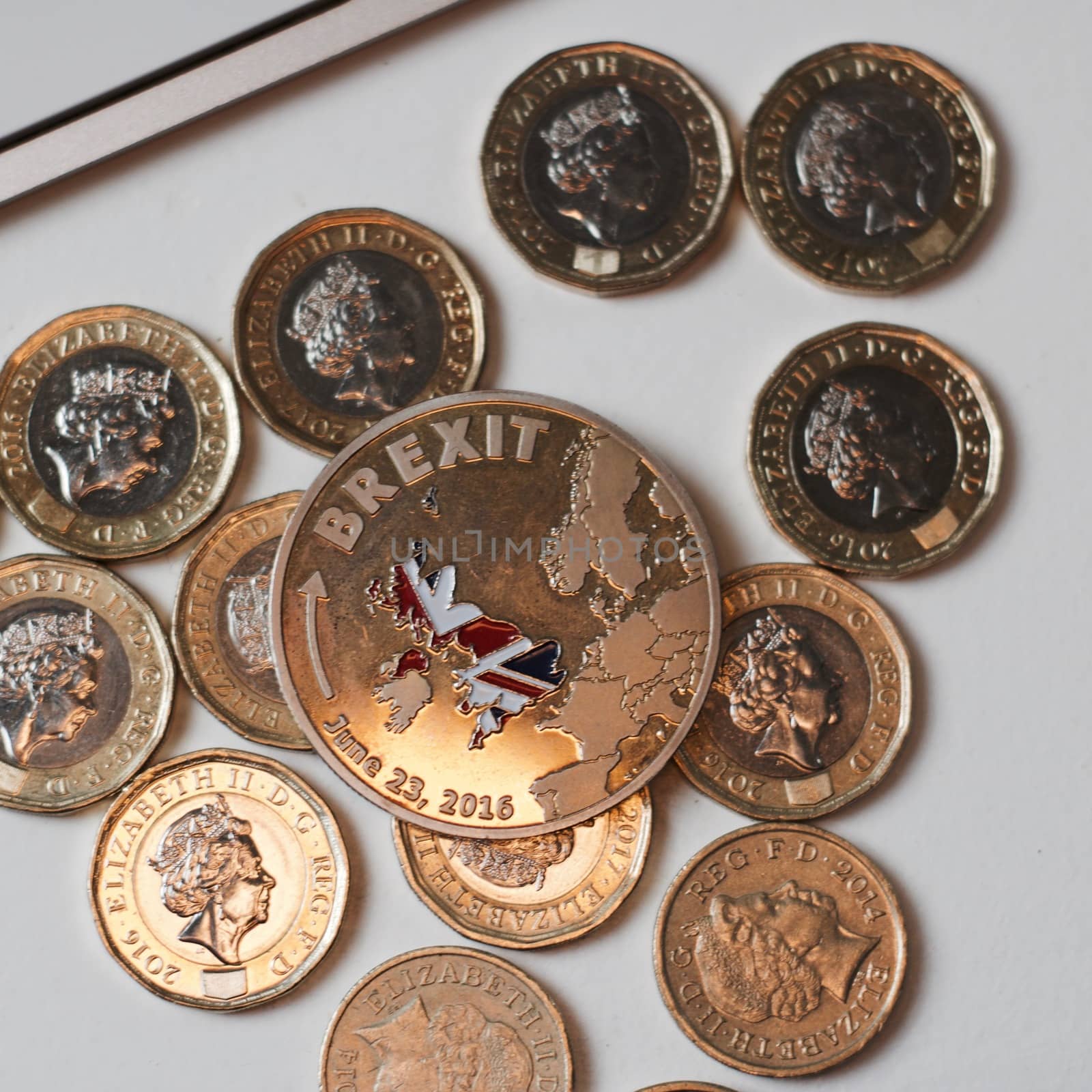 Europe leaving. Gold brexit coin with British map near keyboard and pound sterling.