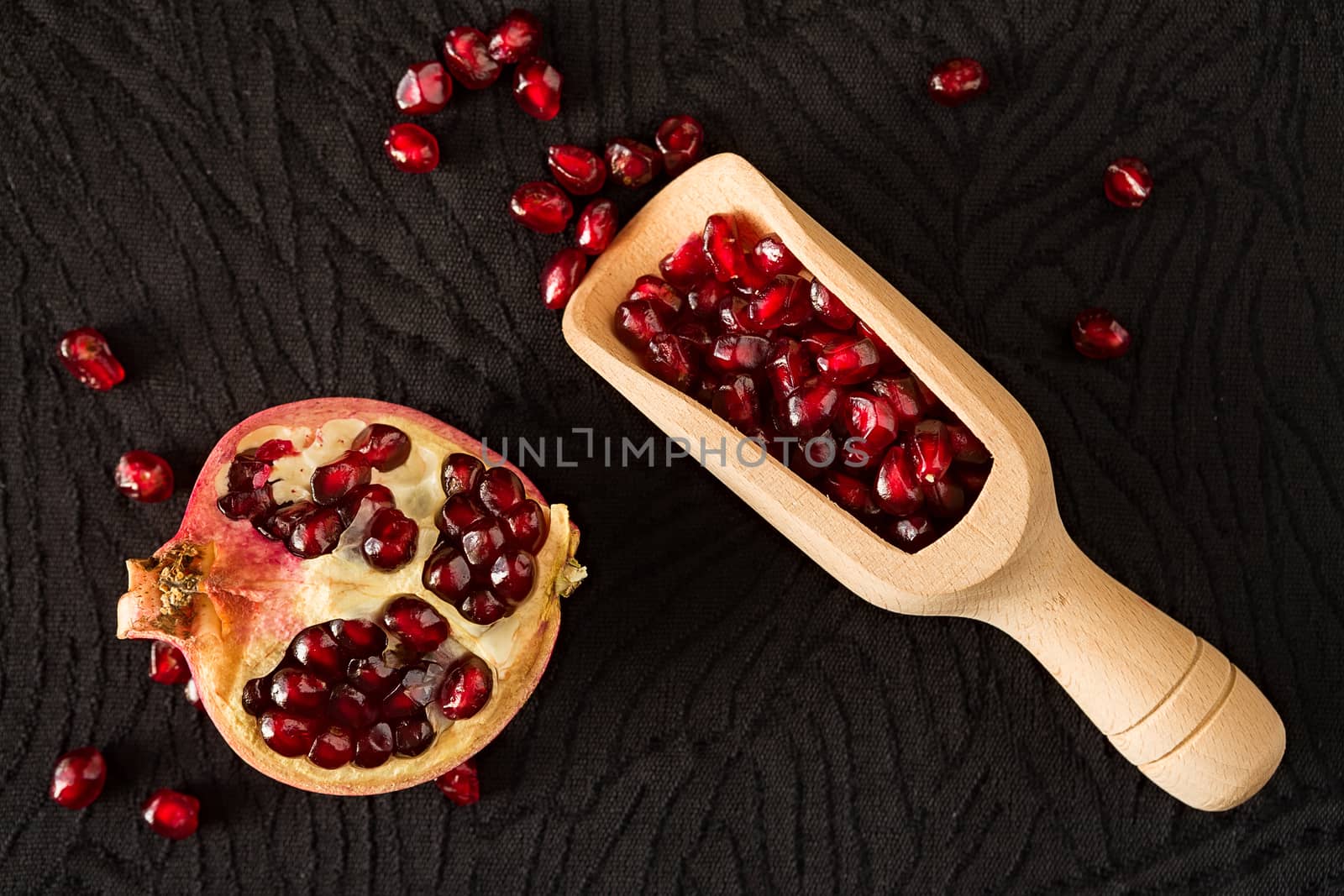 Closeup of half pomegranate fruit and bailer with seeds inside by LuigiMorbidelli