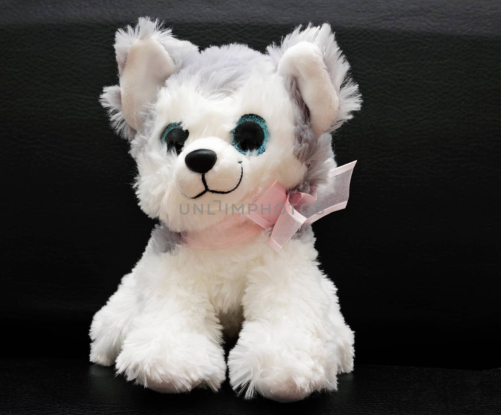 A soft toy is a little white dog. by andsst