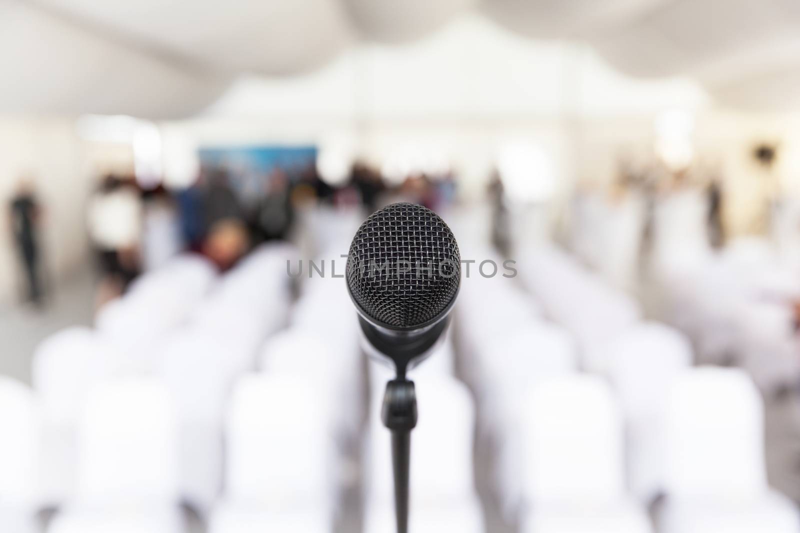 Microphone in focus, empty conference room in the background by wellphoto