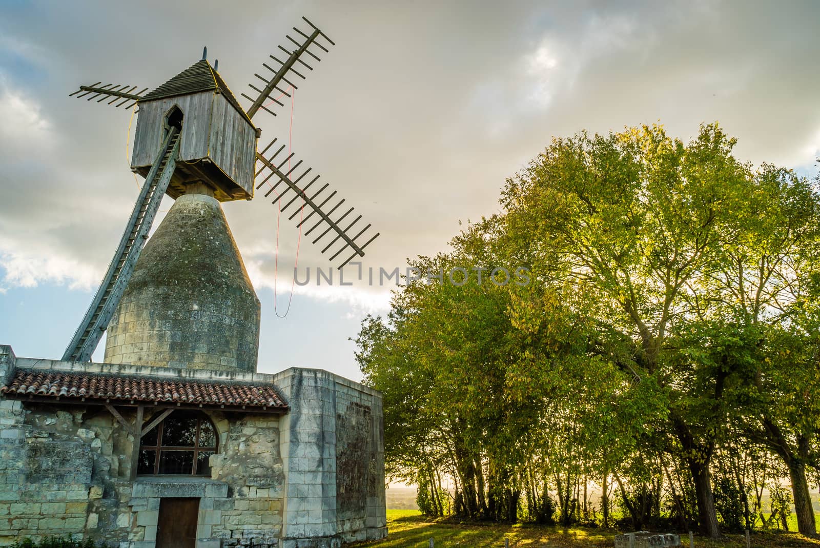 Windwill in France backlit at sunset