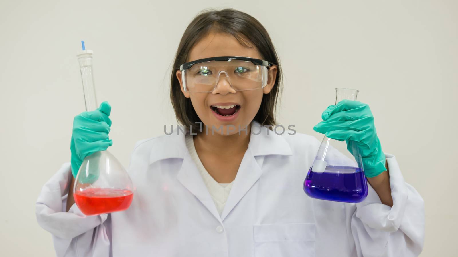 Asian little girl holding test tube or laboratory flask . Education concept.