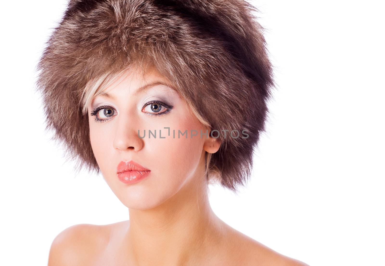 Young woman wearing fur hat isolated on white