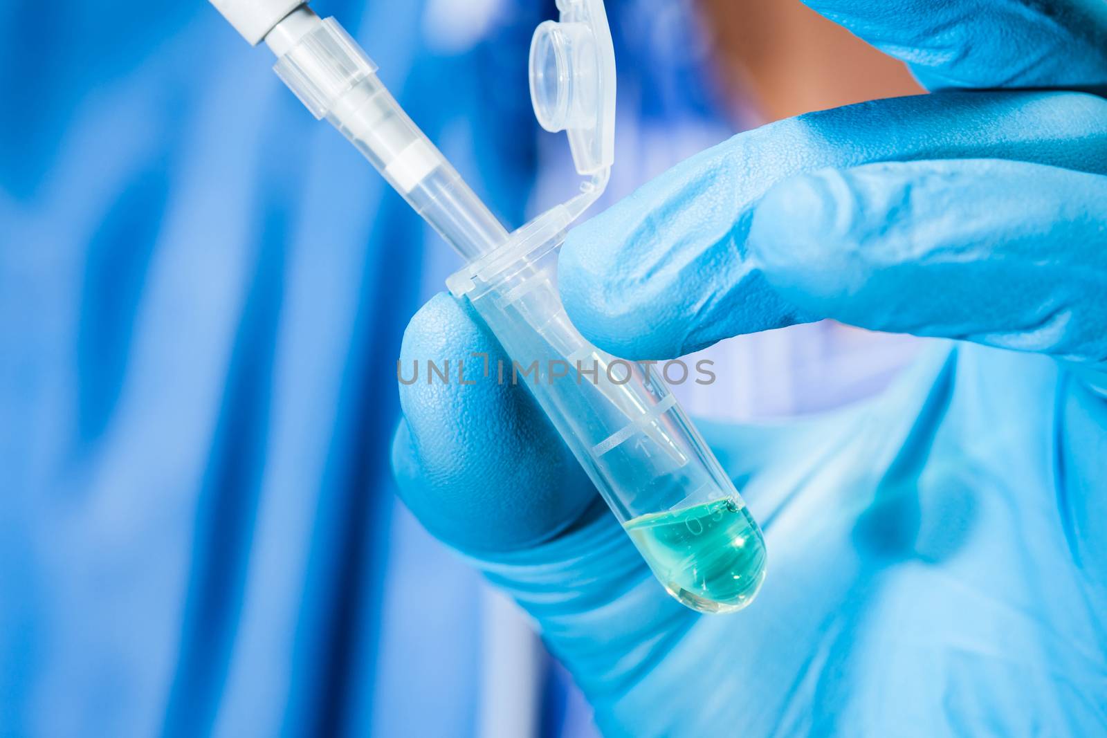 Scientist holding an eppendorf tube and pipette