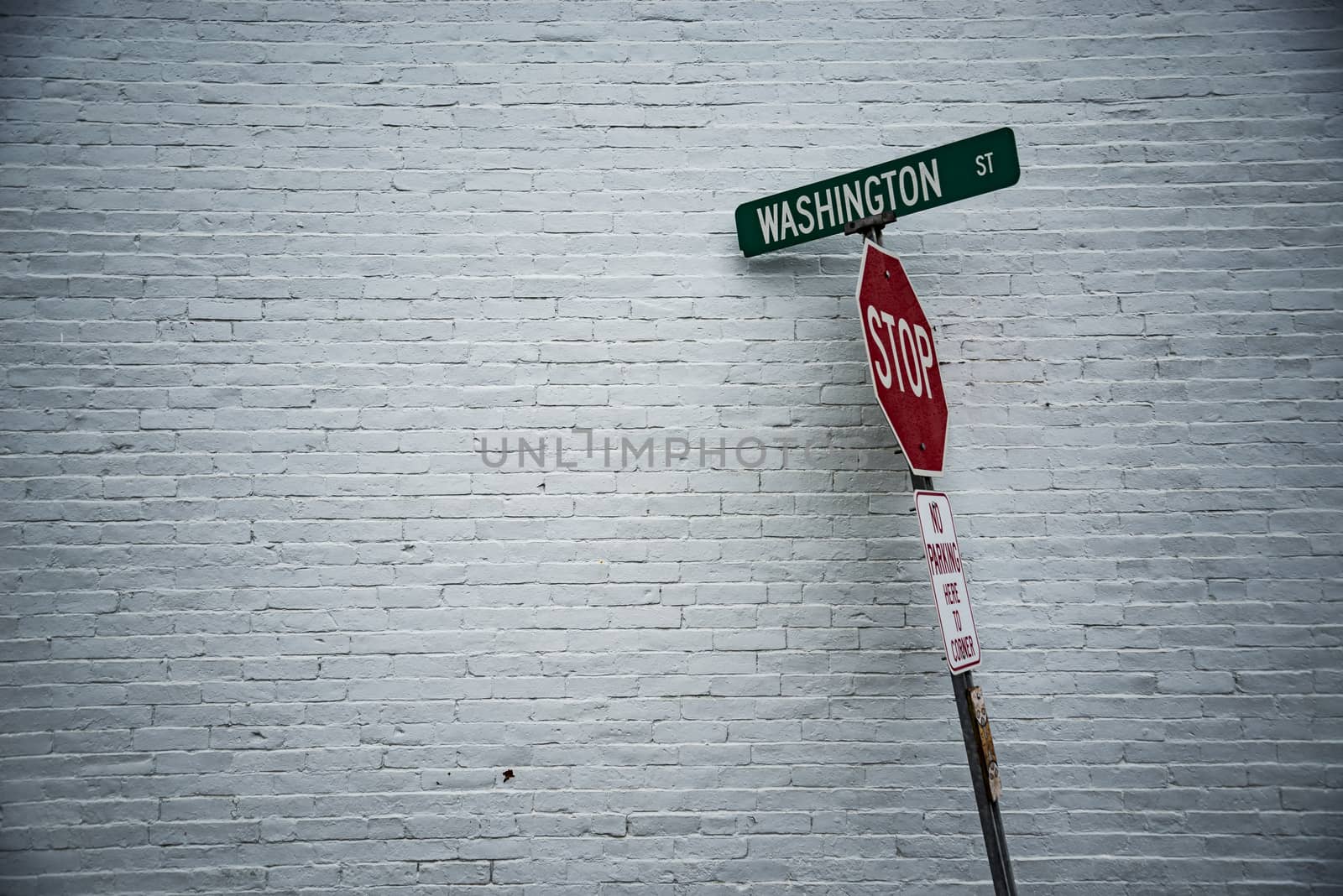 Road sign in front of a white wall by edella