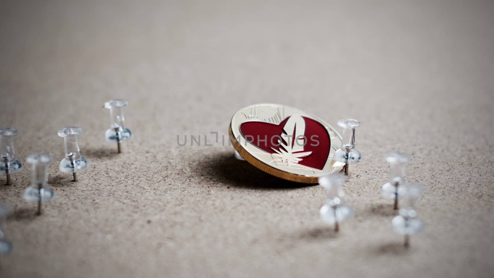 Digital currency physical gold feather coin. Office cryptocurrency concept.