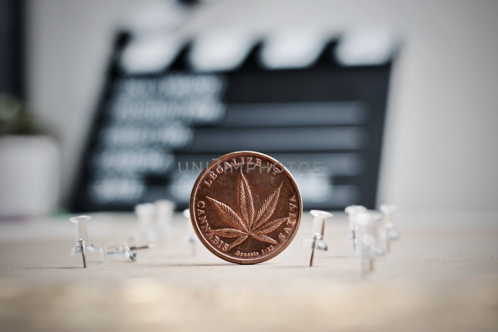Brass marijuana coin in cinema concept. Legalize it, sativa.
