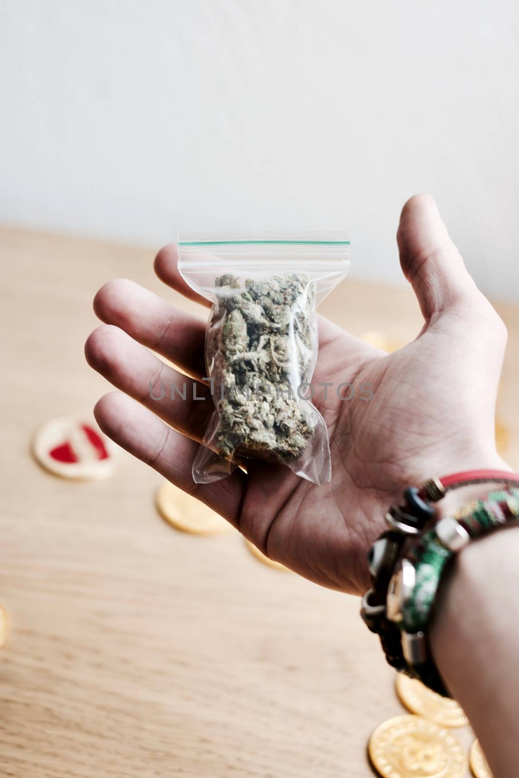 Green dry marijuana in man hand on the blurry background. Weed concept.