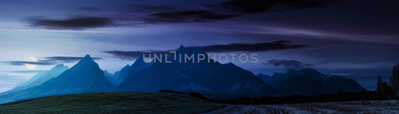 rural fields near Tatra Mountains in summer at night. beautiful panorama of agricultural area. gorgeous mountain ridge with high rocky peaks