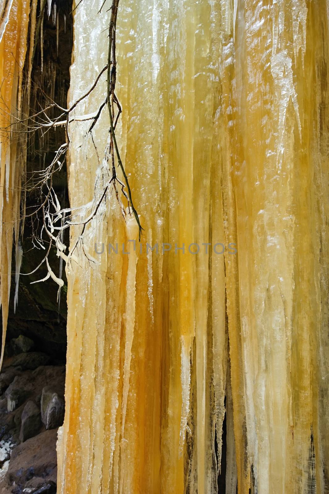 Detail frozen waterfalls on the rock, orange colored 