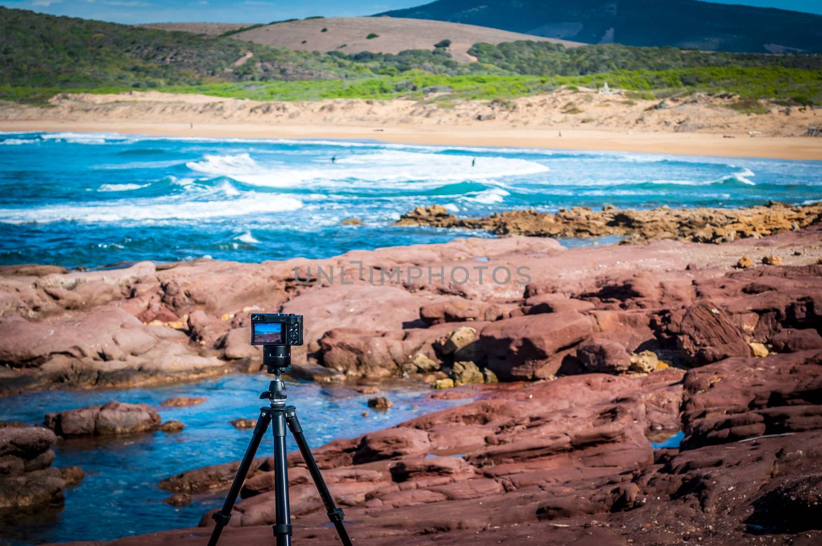 Compact camera on tripod shooting at the coast by replica