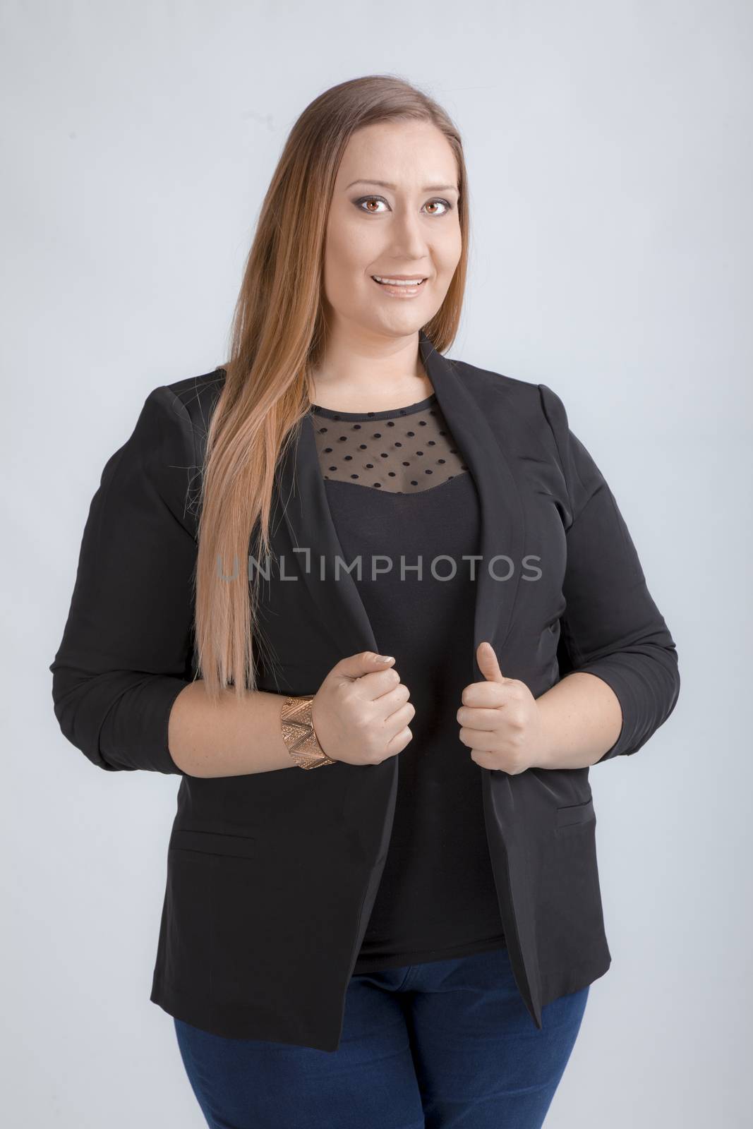 Portrait of a beautiful overweight young woman in casual clothes standing, studio.
